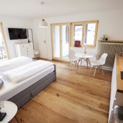 Helles, stilvolles Studio in Bad Wiessee mit komfortablem Bett, Küchenzeile und Balkonzugang. Ideal für Paare.