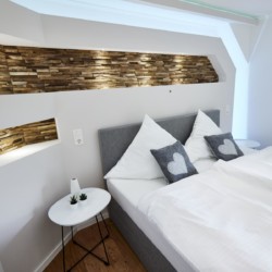 Gemütliches Schlafzimmer in Ferienwohnung am Tegernsee, stilvoll mit Holzakzenten. Ideal für Erholung in Bad Wiessee!