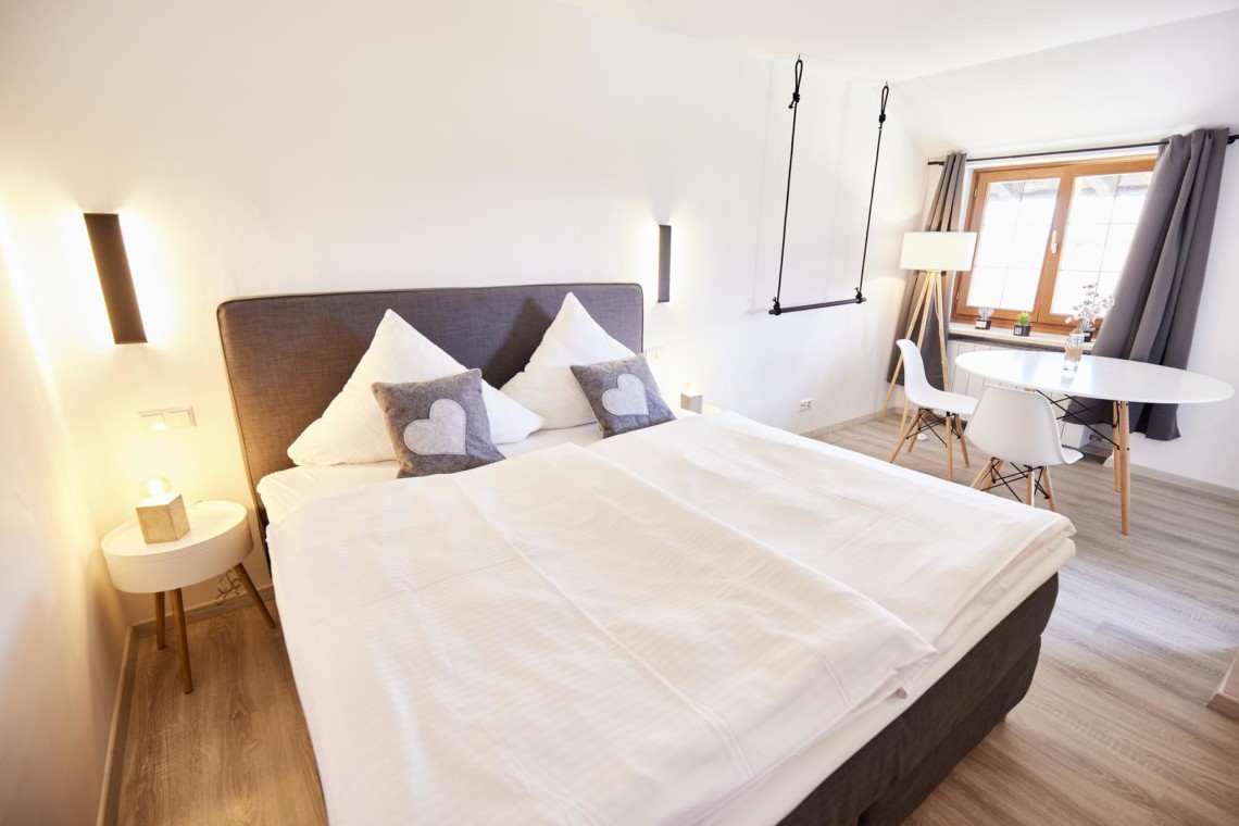 Gemütliches, helles Schlafzimmer mit Doppelbett, modernem Design, in einer Ferienwohnung mit Seeblick in Bad Wiessee.