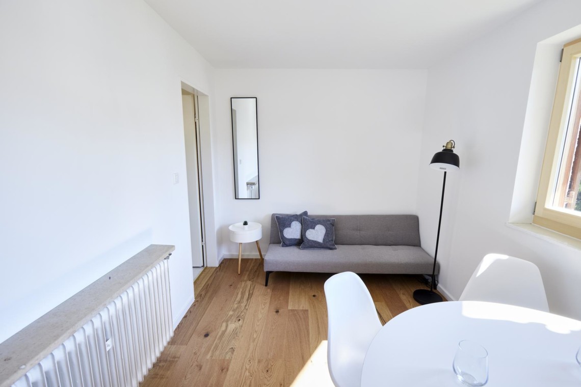 Gemütliches Wohnzimmer in einer Ferienwohnung in Bad Wiessee am Tegernsee, ideal für Paare. Modernes, helles Design.