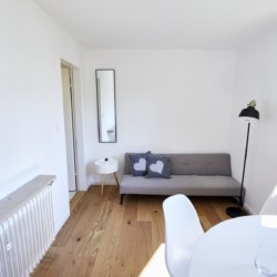 Gemütliches Wohnzimmer in einer Ferienwohnung in Bad Wiessee am Tegernsee, ideal für Paare. Modernes, helles Design.