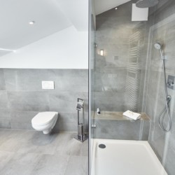 Moderne, stilvolle Ferienwohnungs-Bad in Bad Wiessee mit begehbarer Dusche und elegantem Design.