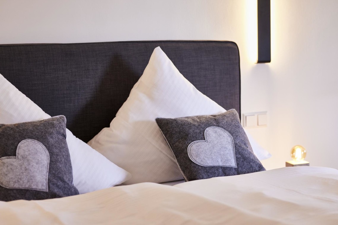 Gemütliches Doppelbett in stilvollem Zimmer in Bad Wiessee, perfekt für Paare auf Erholungsreise. #Ferienwohnung #Seeblick