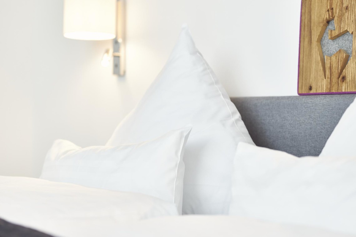 Gemütliches Penthouse in Bad Wiessee: stilvolles Schlafzimmer mit frischer Bettwäsche & modernem Dekor. Buchen Sie Ihren Traumurlaub!