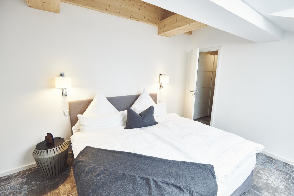 Gemütliches Penthouse-Zimmer in Bad Wiessee mit modernem Design und Holzakzenten.