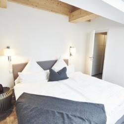 Gemütliches Penthouse-Zimmer in Bad Wiessee mit modernem Design und Holzakzenten.