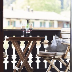 Gemütlicher Balkon mit Bergblick, Weingläsern und Sitzgelegenheiten – ideal für einen entspannten Aufenthalt in Bad Wiessee.
