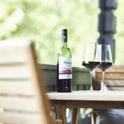 Gemütliches Balkon-Setting mit Weinflasche und Gläsern, ideal für Erholung in Bad Wiessee.