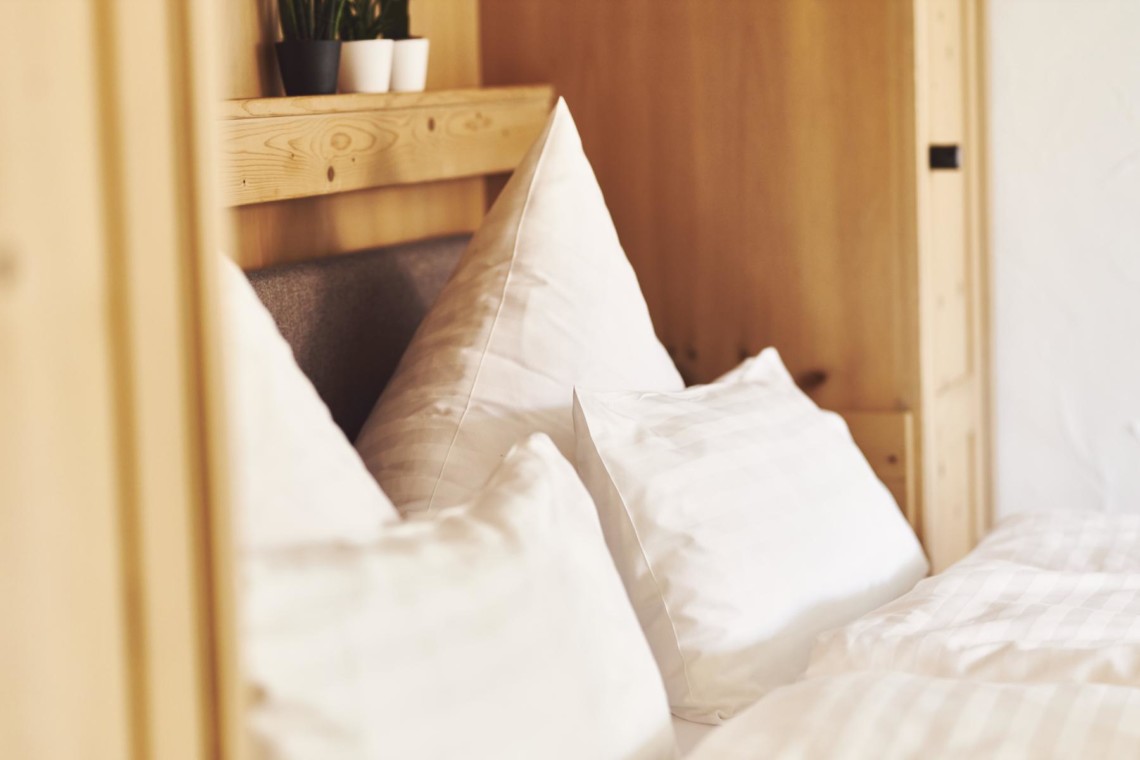Gemütliches Studio-Apartment in Bad Wiessee mit komfortablem Bett und ansprechendem Holzdesign.
