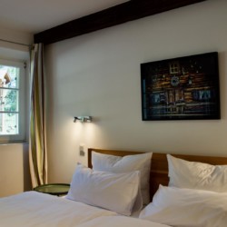 Gemütliches Doppelbett im hellen Zimmer mit Waldausblick nahe Schliersee-Spitzingsee – ideal für Paare.