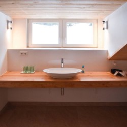 Gemütliches Badezimmer in Ferienwohnung am Schliersee-Spitzingsee, natürliche Materialien, heller Raum.