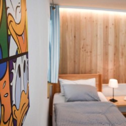 Gemütliches Schlafzimmer in Ferienwohnung #7 bei Schliersee mit modernem Holzdesign und Kunst. Ideal für Ihren Urlaub.