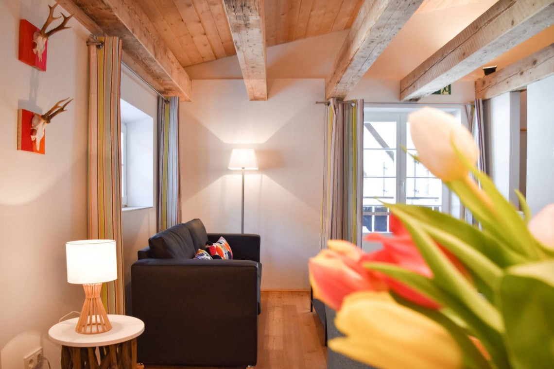 Gemütliches Wohnzimmer in Ferienwohnung #3, Schliersee-Spitzingsee, mit Holzbalken und stilvoller Einrichtung.