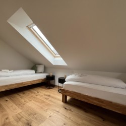 Gemütliches Dachzimmer mit zwei Betten in der Ferienwohnung "Waldkopf", Bayrischzell. Ideal für einen entspannten Urlaub.