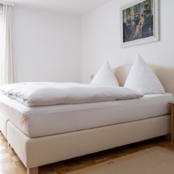 Helles, einladendes Schlafzimmer in einer Ferienwohnung in Bad Wiessee. Ideal für entspannte Übernachtungen.