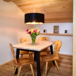 Gemütliches Esszimmer in Schliersee Ferienwohnung #4 mit Holztisch, Stühlen und Blumen. Ideal für einen Urlaub in den Bergen.
