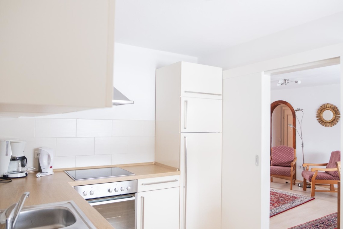 Helle Küche öffnet zu gemütlichem Wohnraum in Bad Wiessee Ferienwohnung.