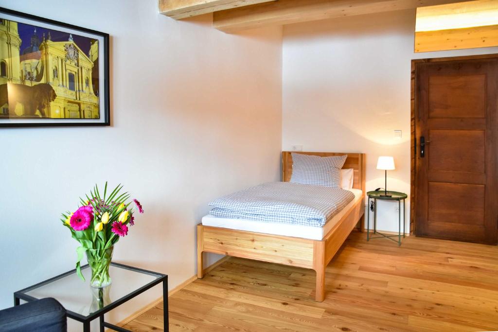 Gemütliches Schlafzimmer in Ferienwohnung, Holzdekor, frische Blumen, nahe Schliersee-Spitzingsee.