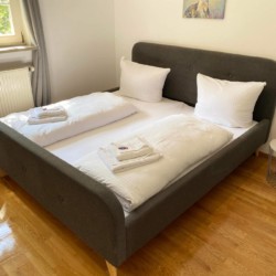 Gemütliches Schlafzimmer in Haushamer Ferienwohnung mit Doppelbett und hellem Interieur. Ideal für einen entspannten Urlaub.