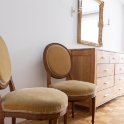 Gemütliche Ecke mit eleganten Stühlen und Spiegel in heller Ferienwohnung, ideal für Urlaub in Bad Wiessee.