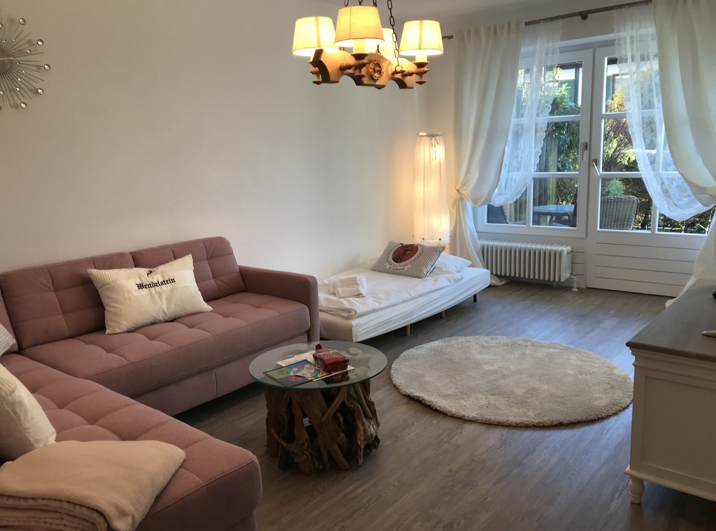 Gemütliches Wohnzimmer einer Ferienwohnung in Schliersee mit Sofa, Licht und modernem Dekor. Ideal für Urlaub.