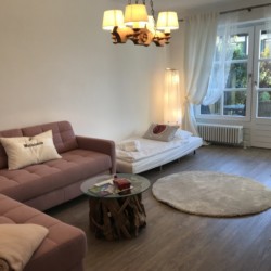 Gemütliches Wohnzimmer einer Ferienwohnung in Schliersee mit Sofa, Licht und modernem Dekor. Ideal für Urlaub.