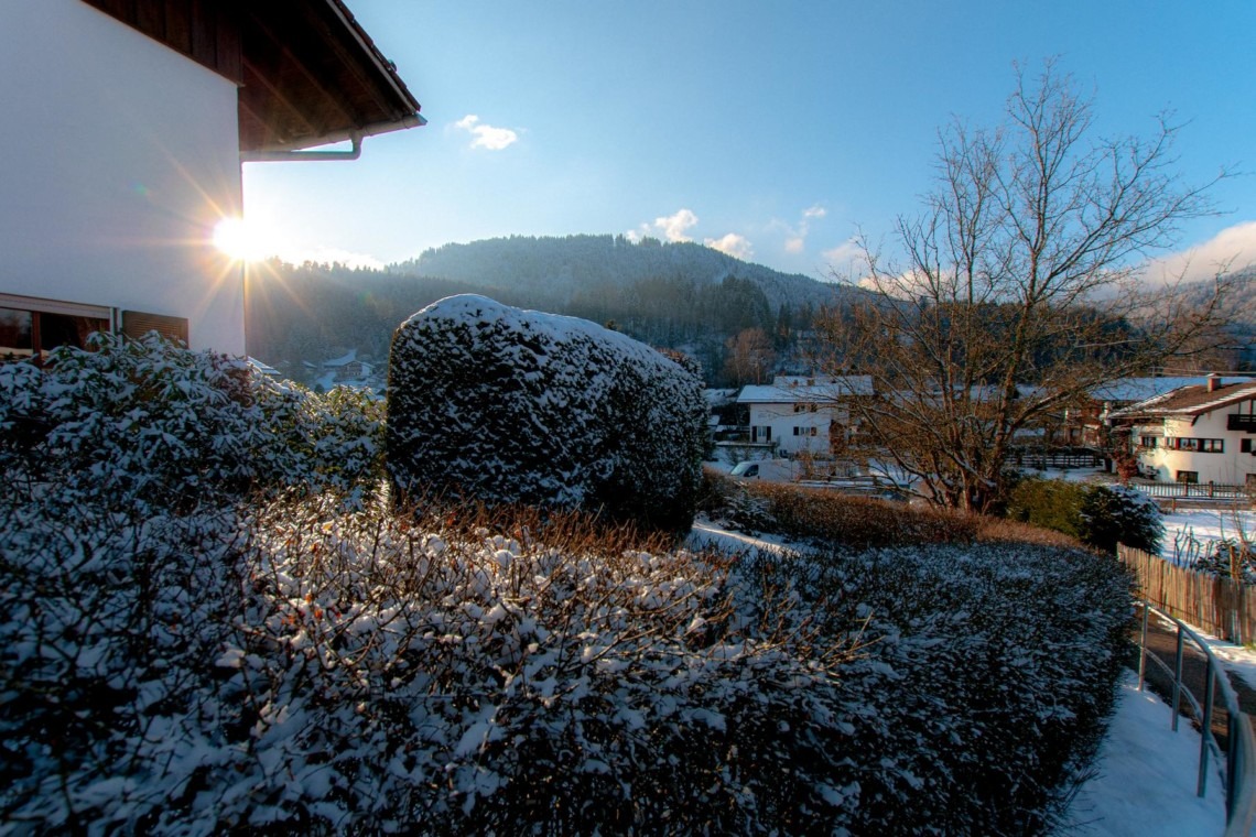 Gemütliche Ferienwohnung in Bad Wiessee mit Blick auf sonnige Berge und winterliche Natur. Ideal für Erholung.