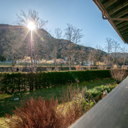 Sonnige Aussicht der Edlen Alpine Suite in Rottach-Egern mit Garten und Bergen. Ideal für Urlaub in idyllischer Natur.