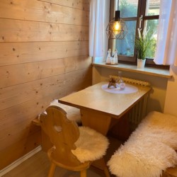 Gemütliches Eckzimmer in Ferienwohnung "Taubenstein" in Schliersee mit Holzverkleidung und stilvoller Einrichtung. Ideal für die Suche nach Ruhe.