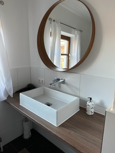 Modernes Bad in Ferienwohnung Taubenstein, Schliersee - stilvolles Ambiente mit Design-Waschbecken und Holzakzenten.