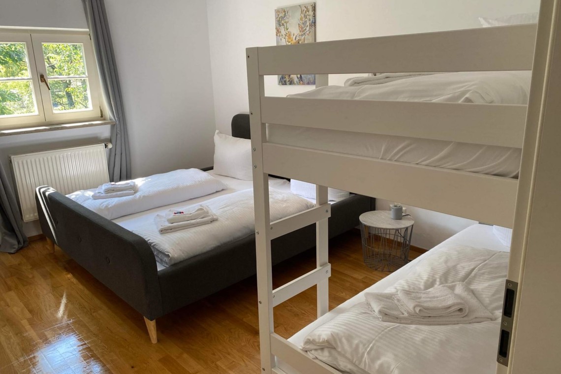 Gemütliches Schlafzimmer in Hausham mit Etagenbett und Doppelbett, ideal für Familien.