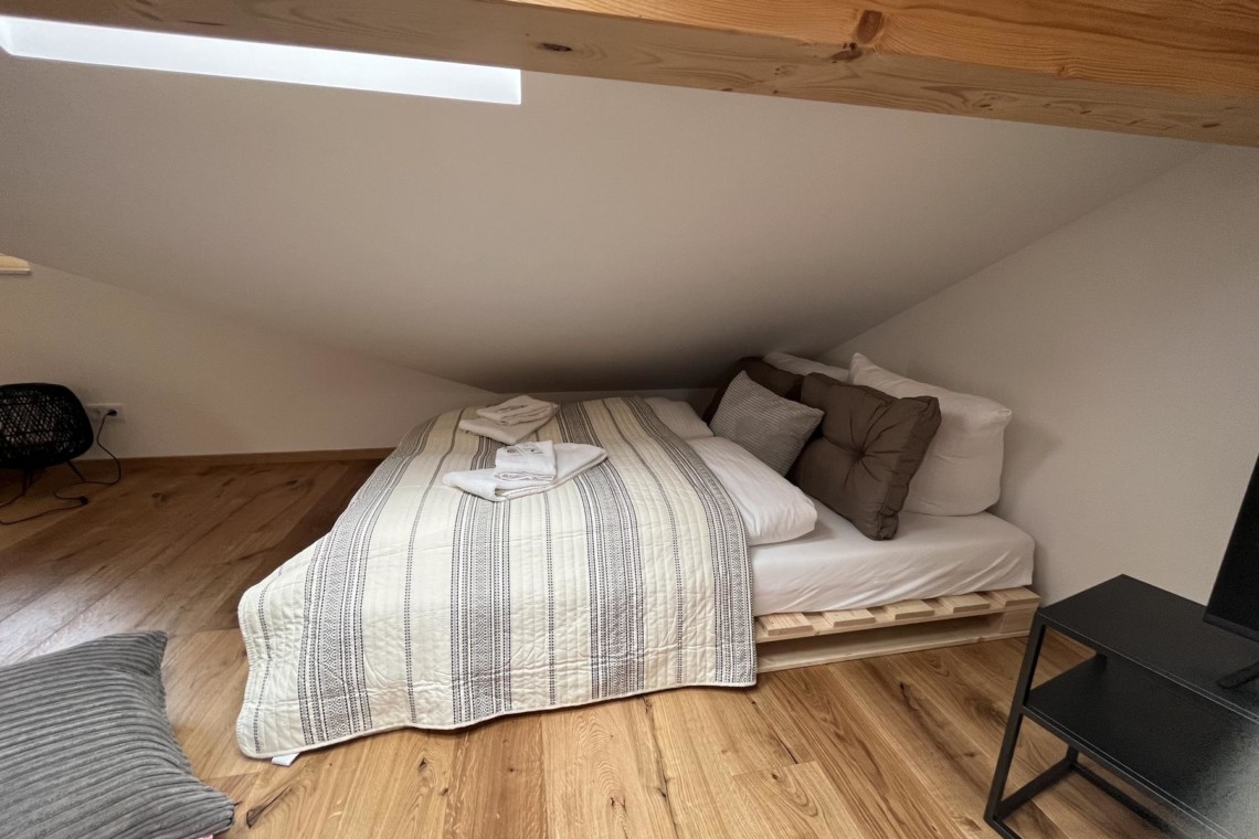 Gemütliches Schlafzimmer in Dachwohnung, Holzoptik, für Urlaub in Bayrischzell. Buchen Sie jetzt bei stayFritz!
