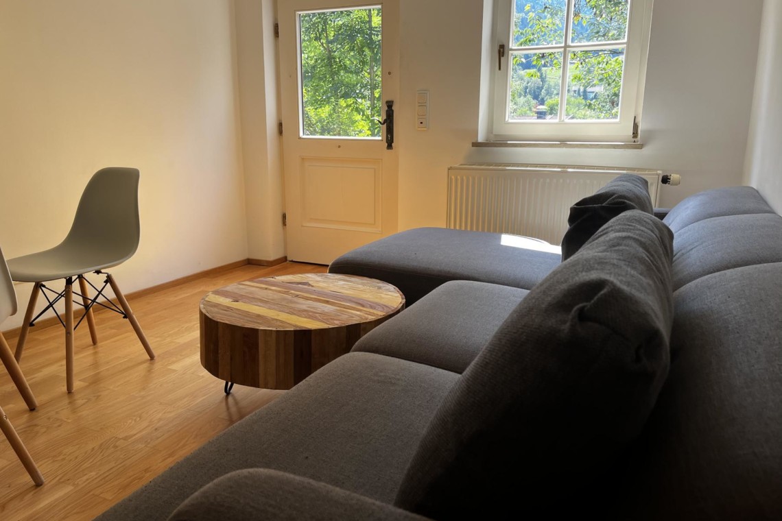 Gemütliches Wohnzimmer in Hausham, helle Ferienwohnung mit Holzfußboden und Blick ins Grüne. Ideal für Erholung.
