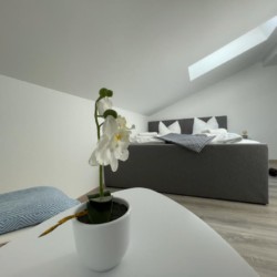 Modernes Penthouse-Apartment in Bad Wiessee mit komfortablem Bett, stilvollem Interieur und gemütlichem Ambiente für einen idealen Urlaub.