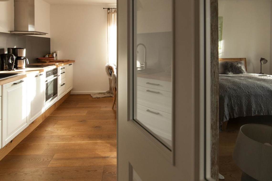 Gemütliche FeWo in Tegernsee mit moderner Küche und einladendem Schlafzimmer, ideal für den Erholungsurlaub.