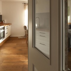 Gemütliche FeWo in Tegernsee mit moderner Küche und einladendem Schlafzimmer, ideal für den Erholungsurlaub.