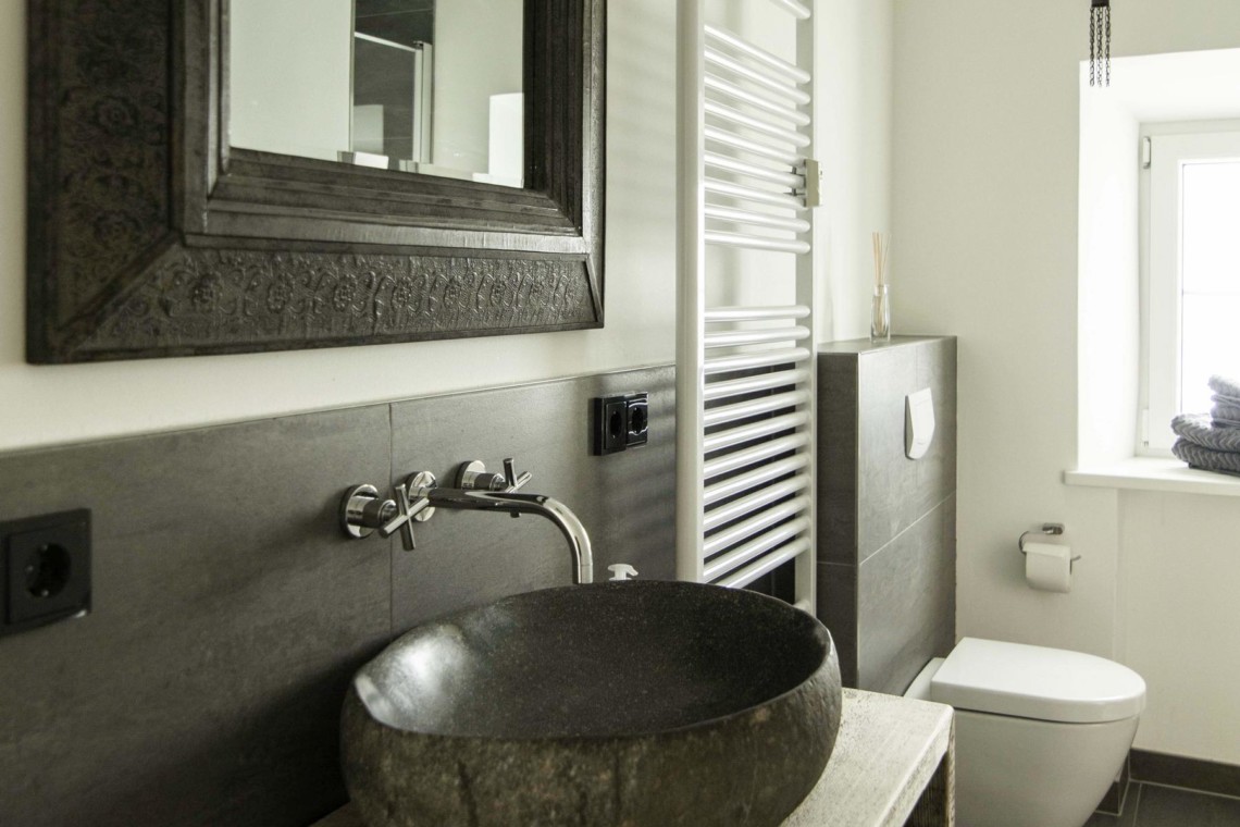 Elegantes Badezimmer in Ferienwohnung am Tegernsee mit stilvollem Waschbecken und modernen Akzenten.