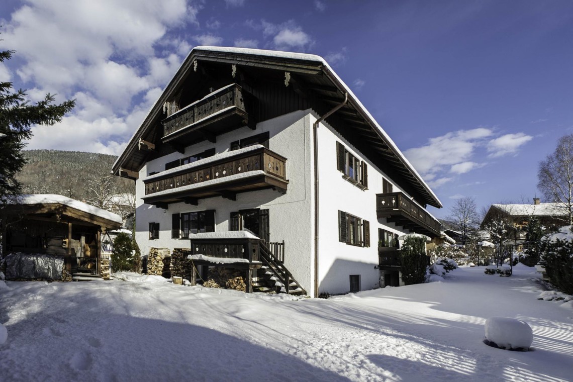 Gemütliches bayrisches Ferienhaus im Schnee mit Balkonen, ideal für Tegernsee-Urlaub.