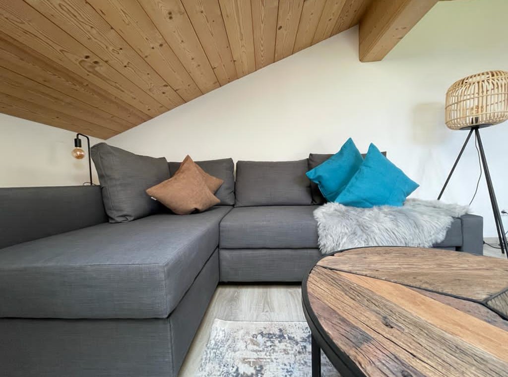 Gemütliches Penthouse in Bad Wiessee mit einladendem Sofa und modernem Design, ideal für Erholung im Urlaub.