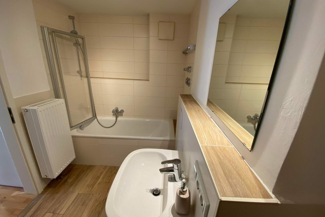 Helles Badezimmer mit Dusche, Wanne und Spiegel in Hausham - ideal für eine entspannte Auszeit.