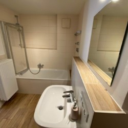 Helles Badezimmer mit Dusche, Wanne und Spiegel in Hausham - ideal für eine entspannte Auszeit.