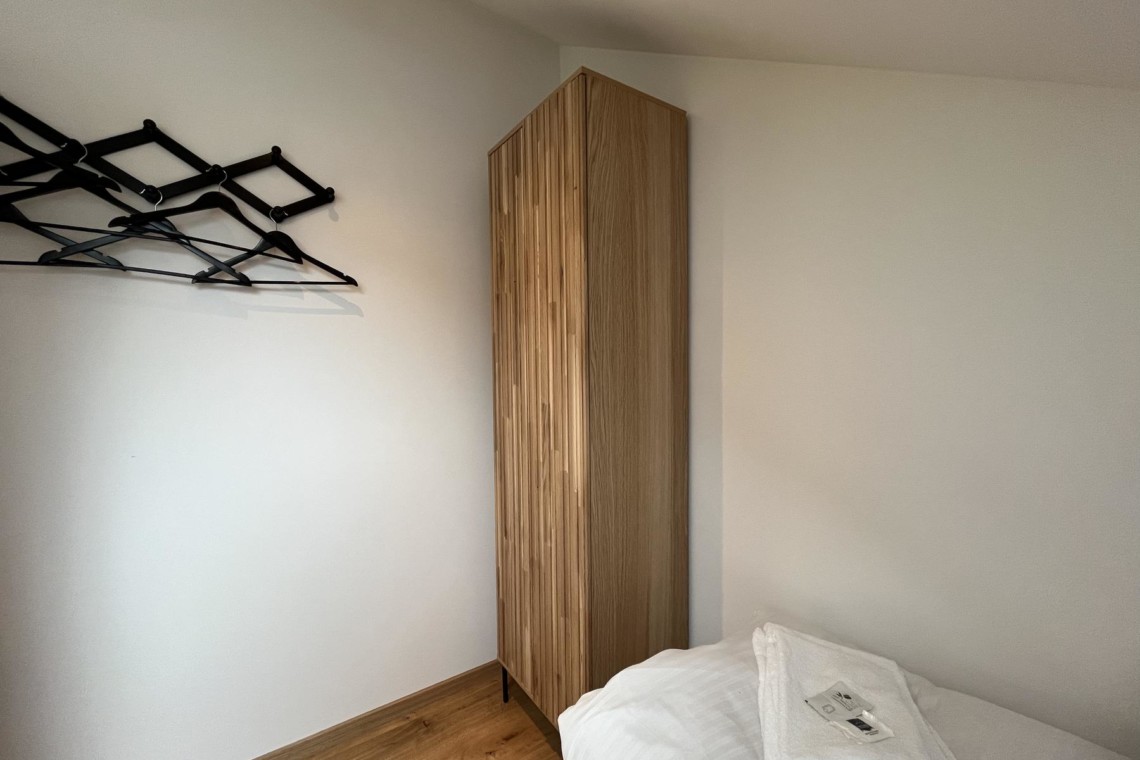 Gemütliches Schlafzimmer in Bayrischzell Ferienwohnung mit Holzschrank und modernem Dekor. Ideal für entspannten Urlaub.