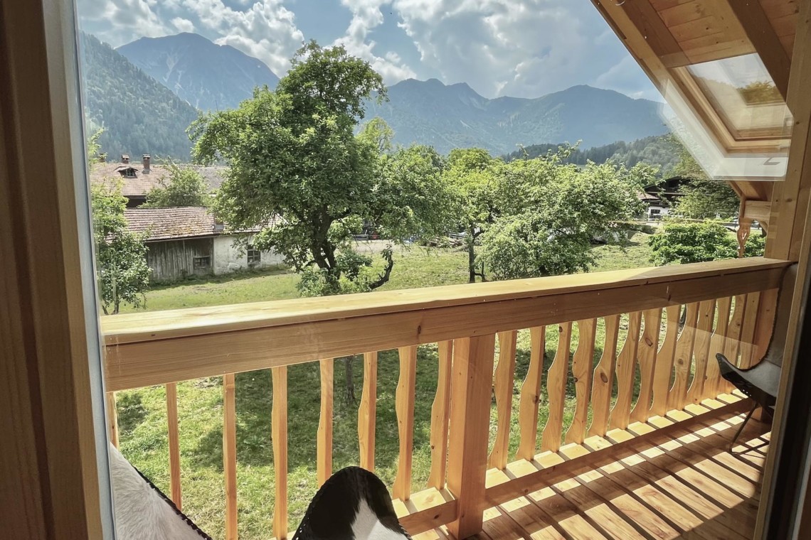 Gemütlicher Balkonblick der Ferienwohnung Heuberg in Bayrischzell mit Bergen, ideal für Erholung.
