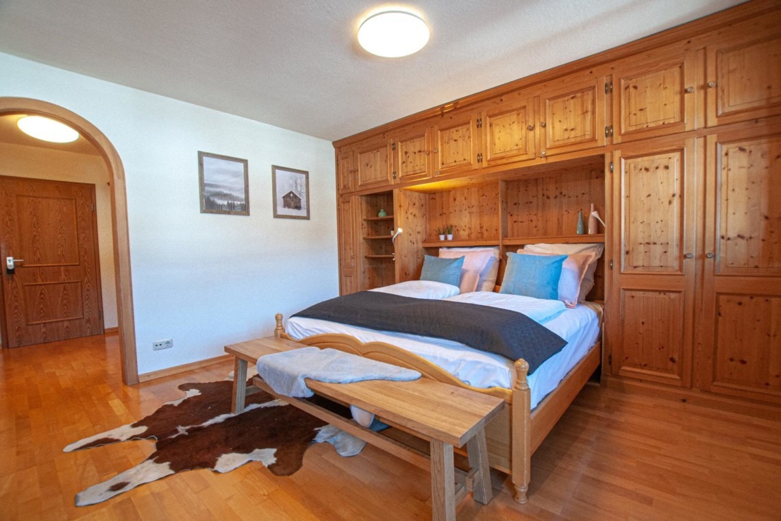 Gemütliches Schlafzimmer in Holz, alpines Flair für entspannte Nächte in Bad Wiessee.