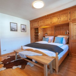 Gemütliches Schlafzimmer in Holz, alpines Flair für entspannte Nächte in Bad Wiessee.