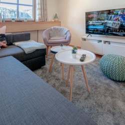 Gemütliches Wohnzimmer in Bad Wiessee mit Sofa, TV & hellem Interieur. Ideal für Entspannung. #Ferienwohnung #BadWiessee