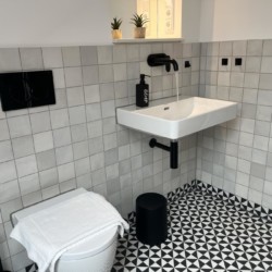 Modernes weißes Bad mit stilvollen Fliesen, in Bayrischzell. Ideal für Ihren komfortablen Ferienaufenthalt.