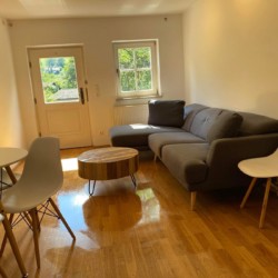 Helles, gemütliches Wohnzimmer in Haushamer Ferienwohnung "Schlierachblick" mit modernem Mobiliar und Holzboden.