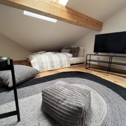 Gemütliches Dachgeschoss-Zimmer mit Holzbalken, TV und moderner Einrichtung in Bayrischzell.