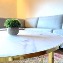 Gemütliches Apartment in Bad Wiessee: stilvoller Wohnbereich mit modernem Tisch, eleganter Couch und ansprechender Deko.